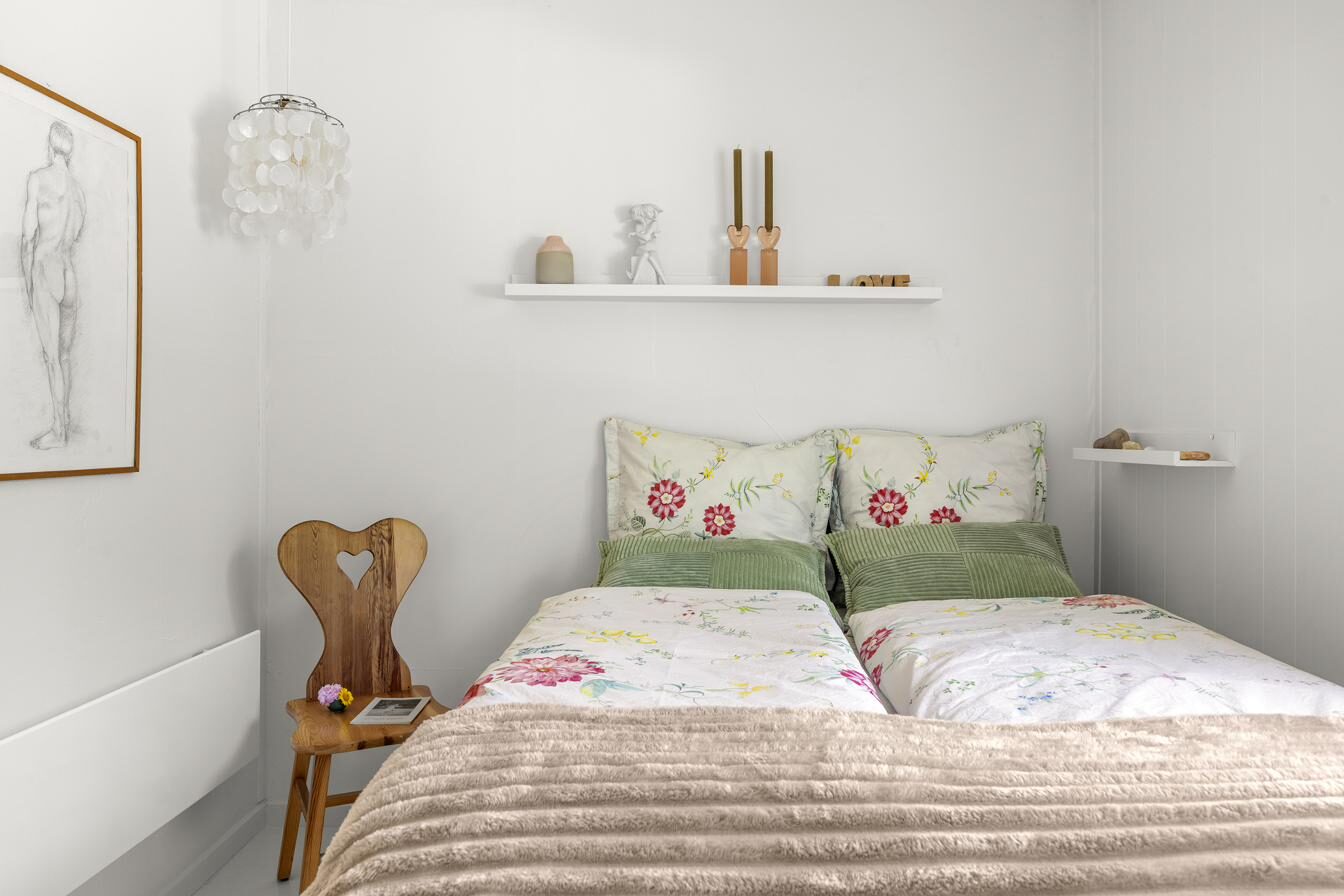 Lyst soveværelse med blomstret sengetøj – sommerhus Vejby Strand